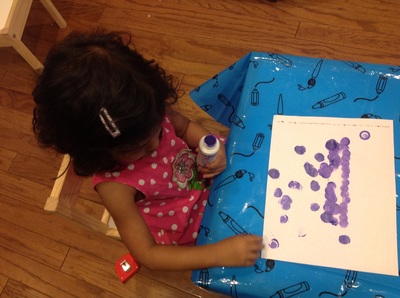 Child playing with yellow/blue materials