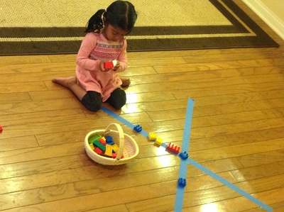 Child playing with yellow/blue materials